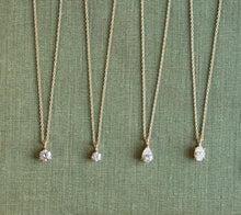 Gold necklaces with fancy diamonds on a green fabric background